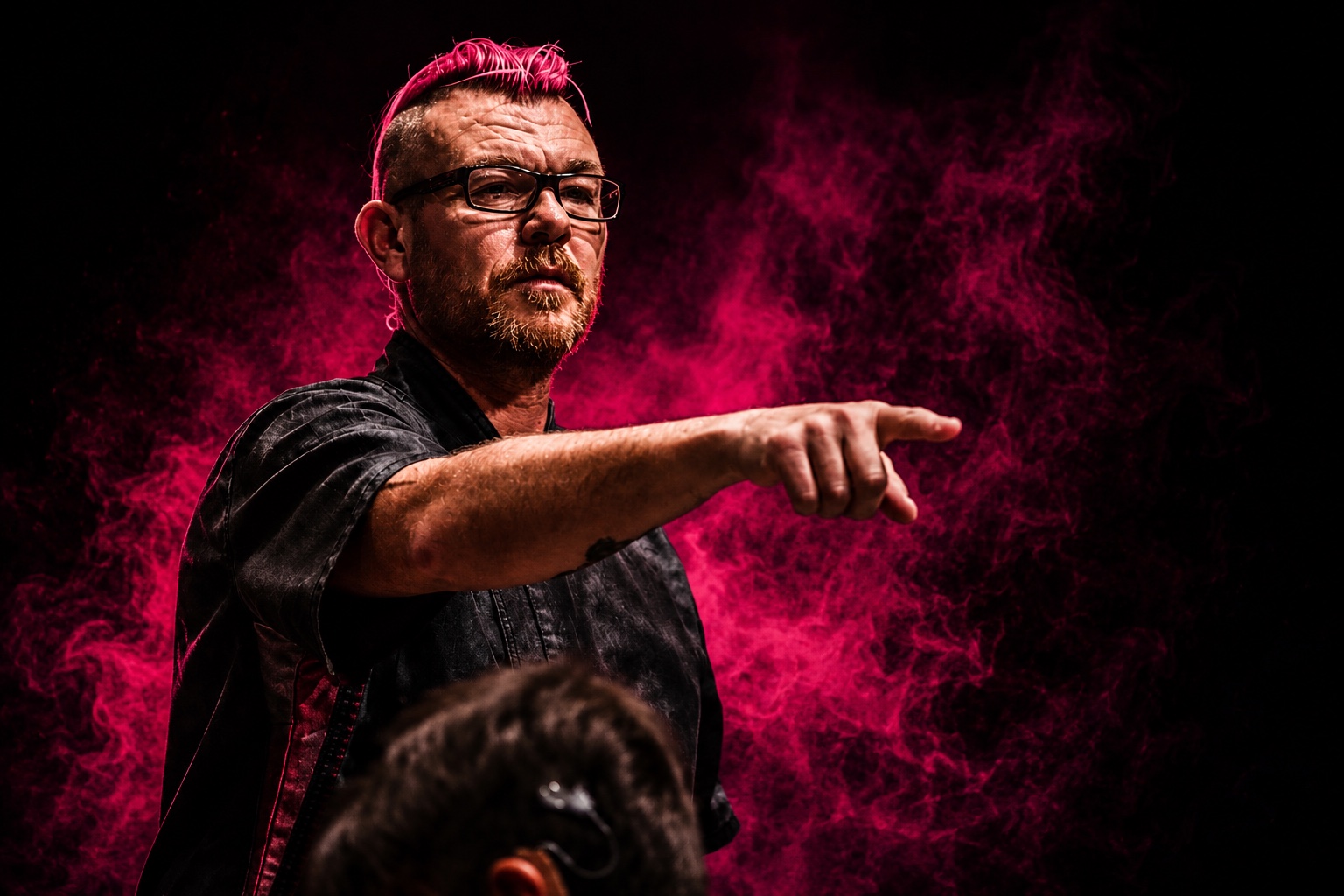Punk Chef pointing while addressing an audience against vivid pink smoke